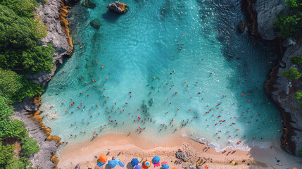 Aerial view of a vibrant beach scene with colorful umbrellas, sunbathers, and swimmers in turquoise waters on a sunny day.
