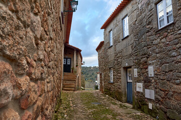 two narrow stone streets in an old european country village with stairs leading to the door