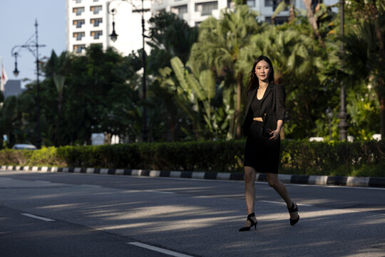 women in business attire crossing road