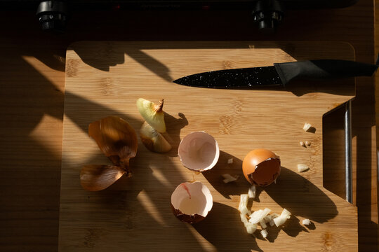 Cocking  breakfast in sunny lights.
eggs shell and part of onions. 