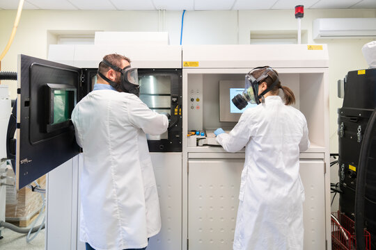 People Using 3D Printer in Laboratory Room