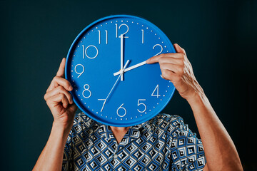 man resets a blue clock