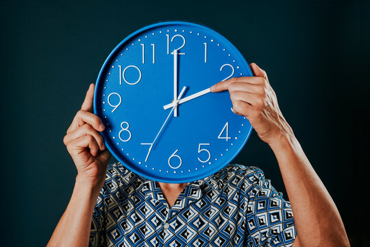 man resets a blue clock