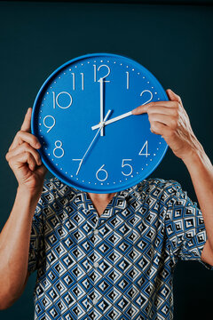man resetting a blue clock