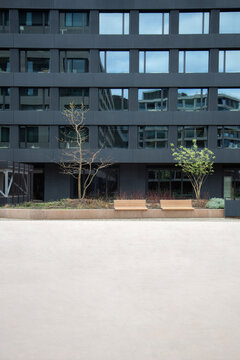 Black modern building with windows and an empty concrete in front