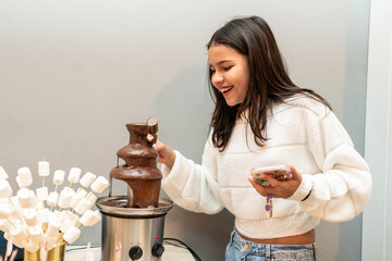 Girl enjoying a chocolate fountain.