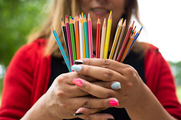 a person holding up a group of colored pencils in their hands
