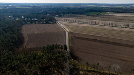 a view of an old, farm land with a plane in the sky