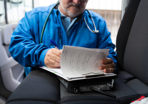 Doctor reviewing medical documents in car