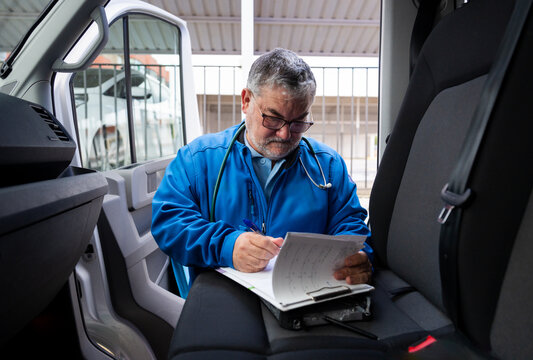 Paramedic filling out a doctor's report in an ambulance