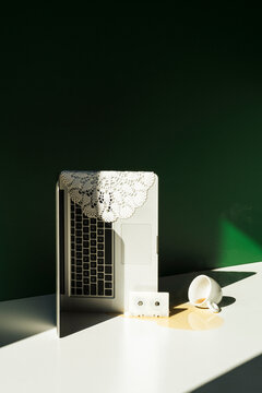 A laptop and retro objects with a spilled cup of coffee