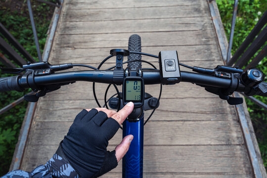 Setting up a bike computer on mountain bicycle handlebar. Preparing for a bicycle trip.