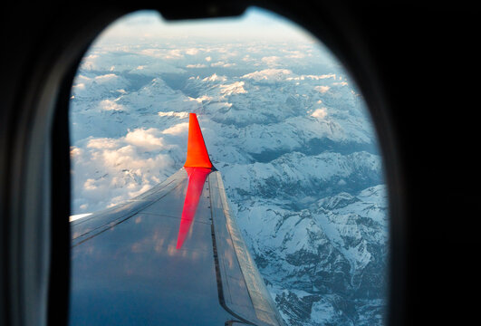 Aerial View From The Plane Of Alps Mountains At Sunset.