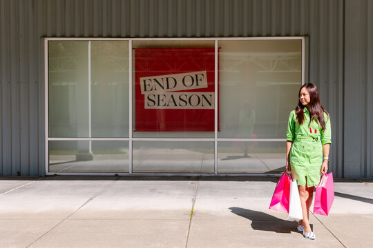 Woman by End of Season store sign