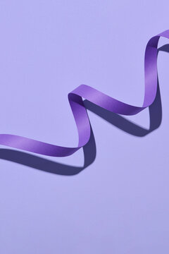 Purple curly ribbon isolated on purple background.