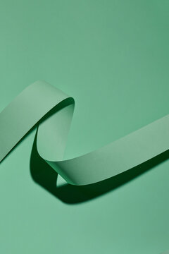 Curved color paper ribbon on a green background.