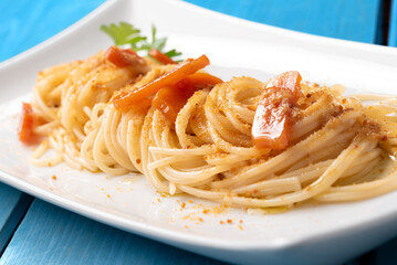 Piatto di deliziosi spaghetti conditi con bottarga di muggine, pasta italiana, cibo mediterraneo 