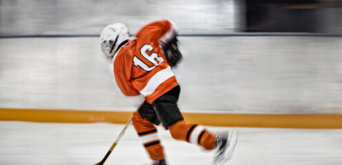 Youthful hockey player swiftly gliding across the ice