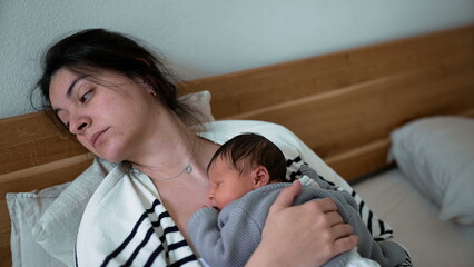 Tired Mother and Newborn Asleep Together During Afternoon Nap in First Week of Life, mom struggling...