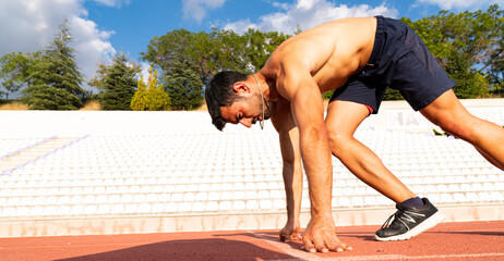 Stadium, man running and start block of athlete on a runner and arena track for sprint