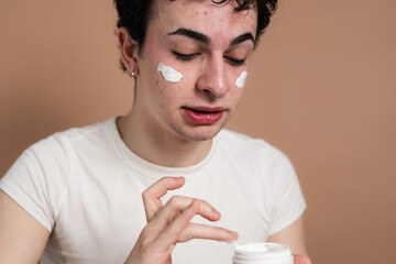 Young person applying facial cream