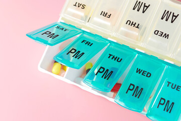 Pill and Capsule Organizer on Pink Background
