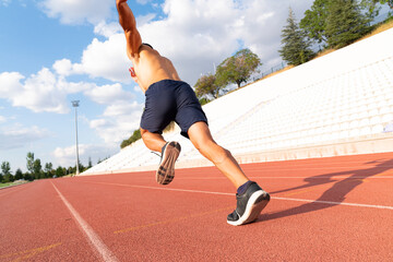 Stadium, man running and start block of athlete on a runner and arena track for sprint