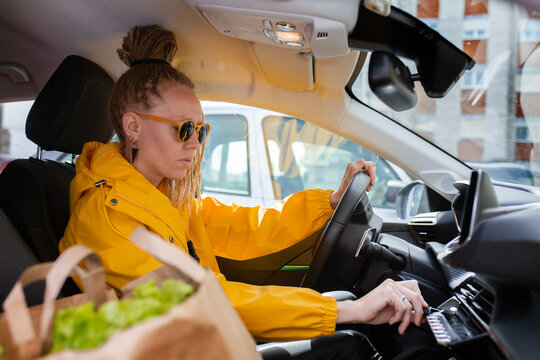 Pretty woman in yellow raincoat wearing sunglasses with dread hairstyl