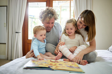 Happy, family and reading book together on bed for learning, development and child education at...