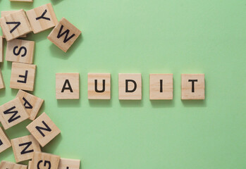 A jumble of wooden blocks spell out the word audit