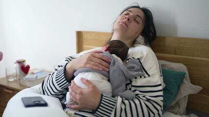 Tired mother sleeping with newborn baby on chest during first days of his life, exhausted mom...