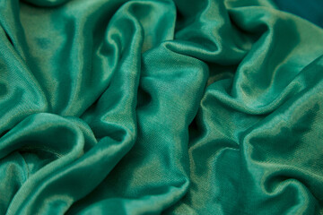 Green silk fabric with numerous gentle folds