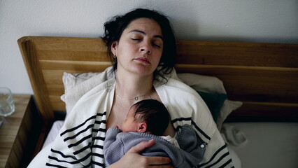 Sleeping Mother cradling newborn baby peacefully in bed asleep holding infant on chest napping...