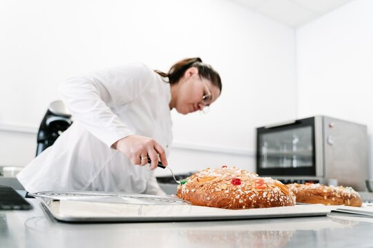 Pastry chef decorating artisan cake in kitchen