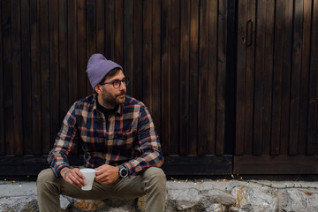 Handsome Man Sitting in Front of House With Coffee Cup 