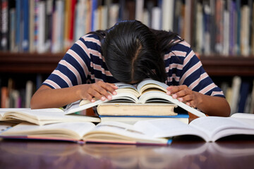 Student, sleeping and library with woman, burnout and course research burnout from project at...