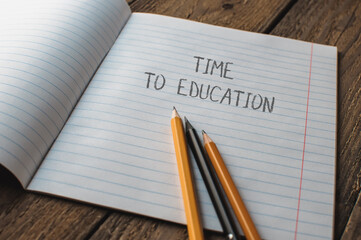 A notebook with pencils on it and the words time to education written on it