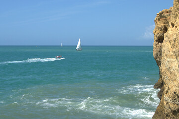 Boats sailing near cliffs at Carvoeiro