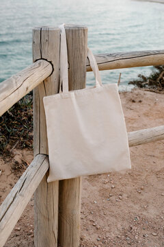 Close-up of a tote bag without patterns hanging from a wooden post