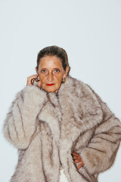 Serious senior woman in fur coat at studio ugc