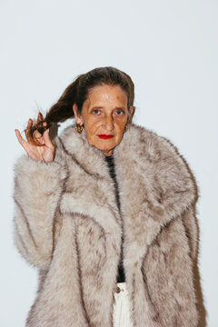 Serious senior woman in fur coat at studio ugc