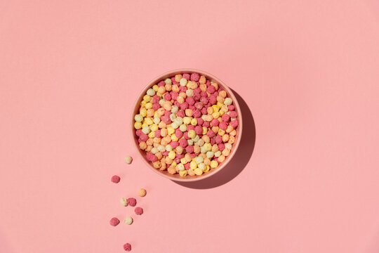 Colorful ball-shaped pop breakfast cereal on pink background
