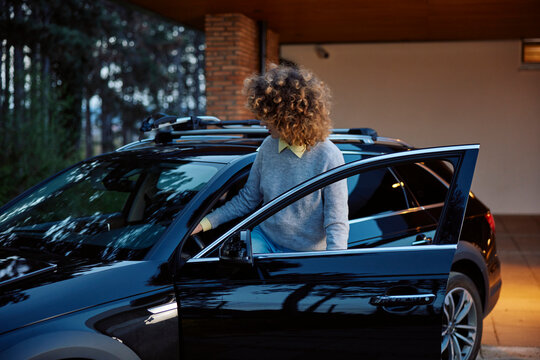 Curly woman gets into the car