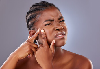 Black woman, portrait and squeezing pimple or blemish in studio with unhappy for cosmetics....