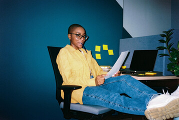 Female employee at workplace with pencil in mouth
