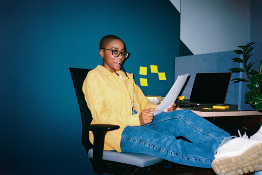 Female employee at workplace with pencil in mouth