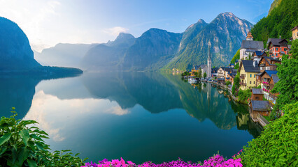 Hallstatt, Austria - A scenic picture postcard view of the famous village of Hallstatt reflecting in Hallstattersee lake in the Austrian Alps. - Powered by Adobe