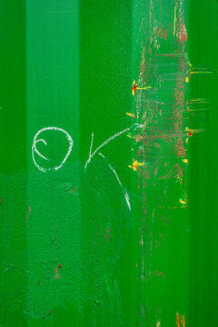 OK scribbled on a green painted wall