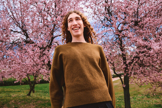 Portrait of a young person surrounded by pink trees.