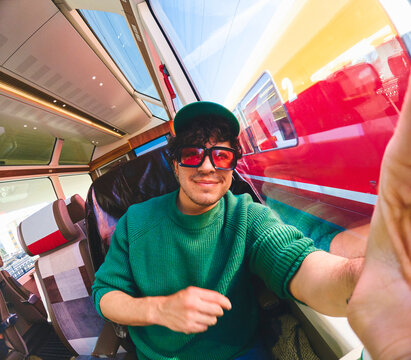 Man taking a selfie in a train while traveling
